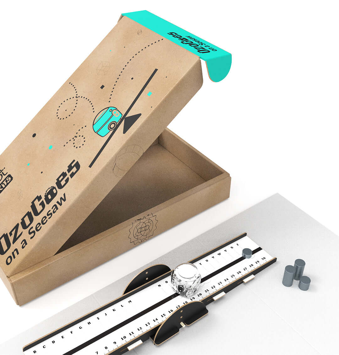 OzoGoes On A Seesaw kit packaging with seesaw apparatus and components for STEAM learning in a classroom setting.