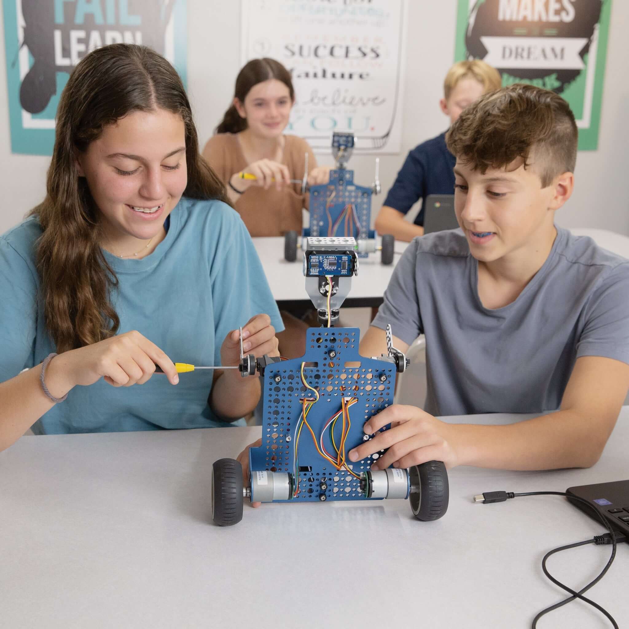 Middle school students engaged in building the Seeker robot, promoting STEM learning and coding skills.