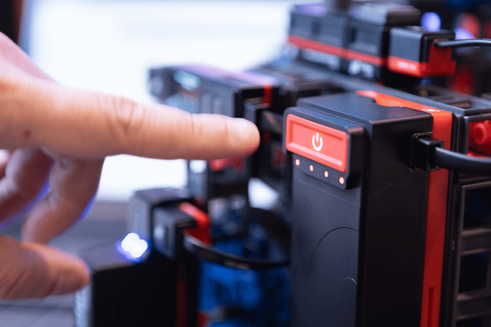 Close-up of a hand pressing the power button on a robotics kit from the Sphero Blueprint Engineering Class Pack.