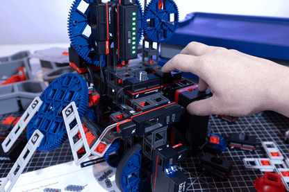 User manipulating components of the Sphero Blueprint Engineering Kit to build a mechanical prototype.