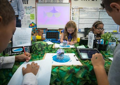 Students engaging in Sphero Computer Science Foundations activities with a robot, tablets, and learning materials.