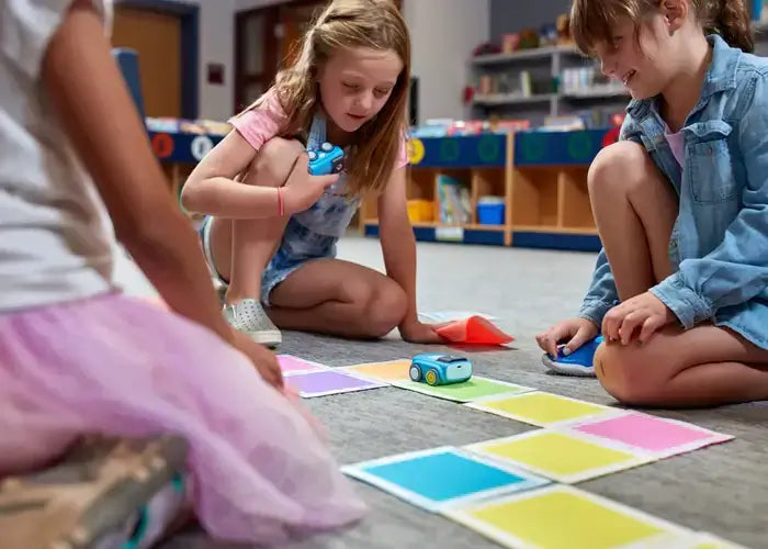 Kids engaging with Sphero indi on color tiles for interactive learning and coding activities in a classroom.