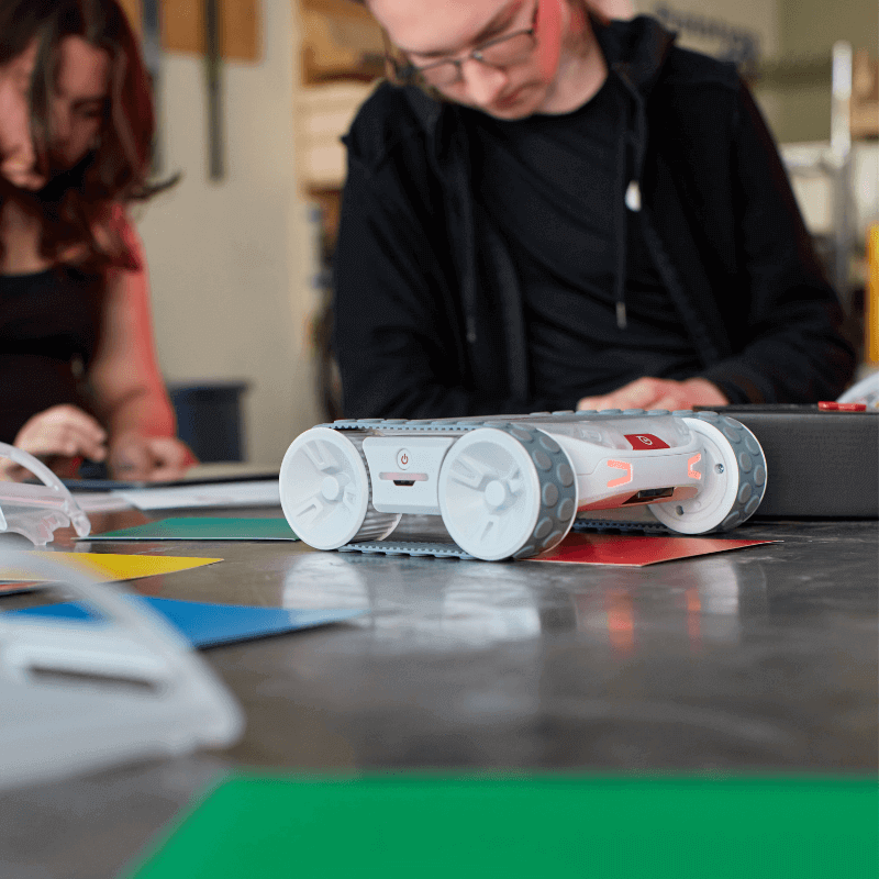 Sphero RVR+ robot on a table with colorful paper, showcasing programmable robotics for educational use.
