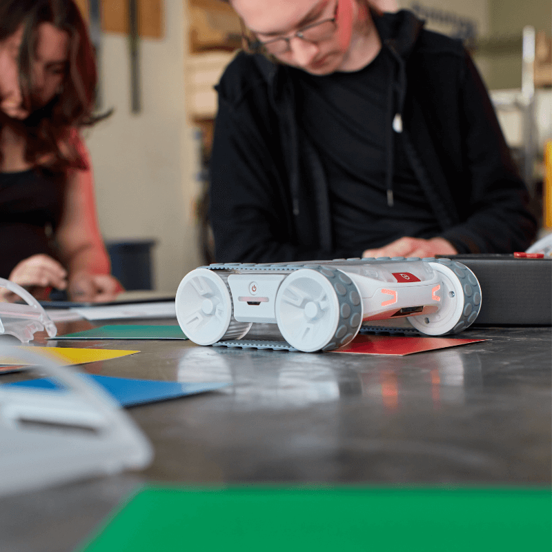 Sphero RVR+ programmable robot on a table with students engaging in coding and hands-on learning.