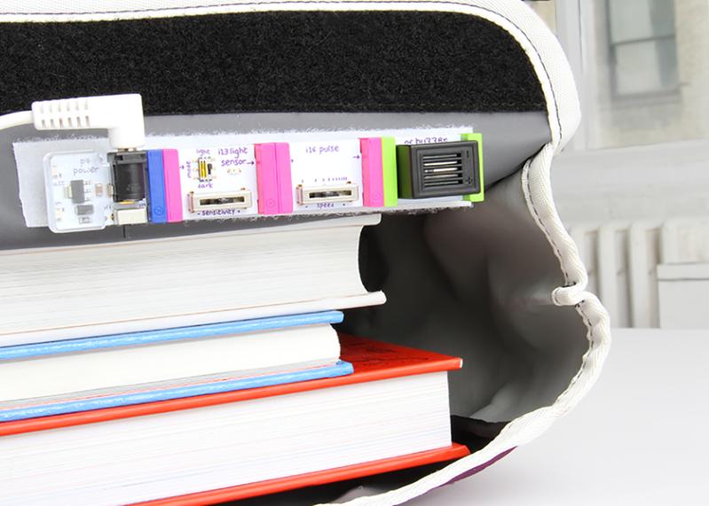 LittleBits STEAM kit with colorful modules alongside stacked books for hands-on learning and engineering.