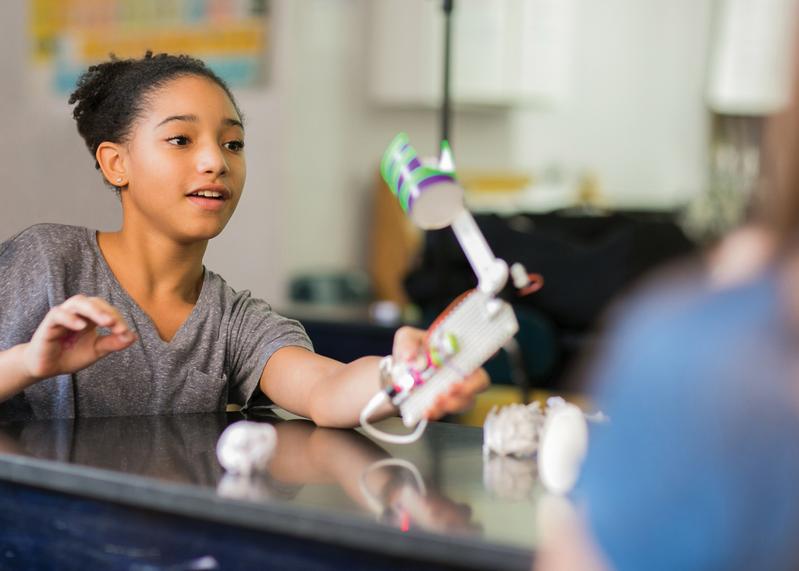Student engaging with LittleBits kit in a classroom, showcasing creativity and hands-on learning in STEAM education.