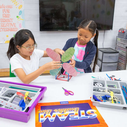Two children engaging in creative play with the STEAM Builder Bin, designing a model using colorful materials and tools.