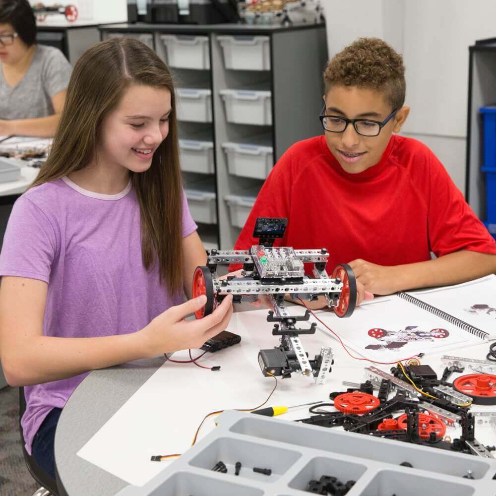 Two students engaged in hands-on robotics building with TETRIX PRIME components in a classroom setting.