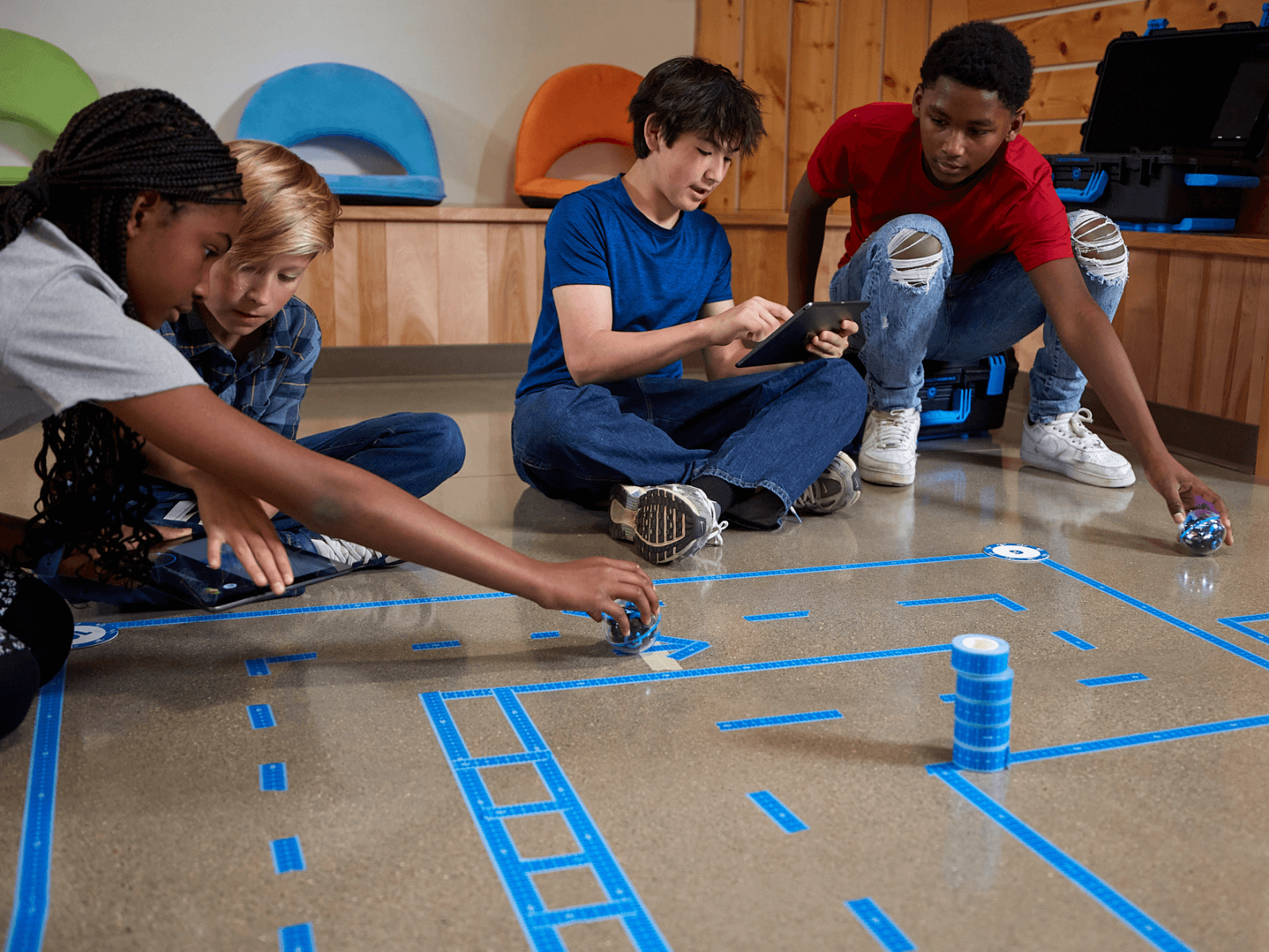 Kids engaging with Sphero BOLT+ robots on a classroom floor, promoting fun learning in coding and robotics.